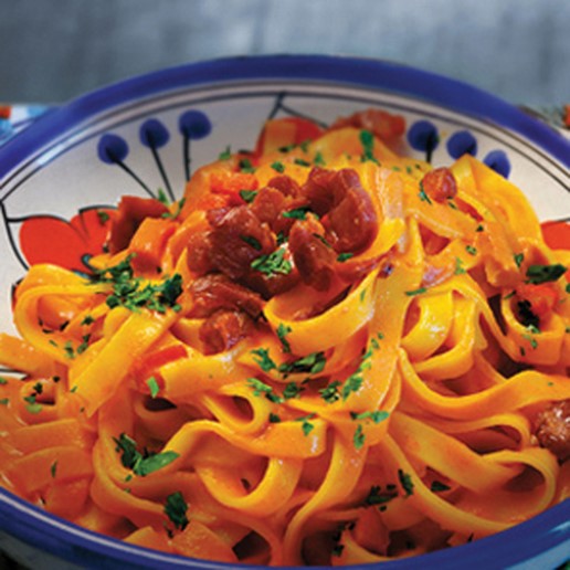 Pasta med tomatflødesauce og bacon i strimler - få opskriften her